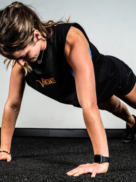 woman in vibe shirt doing a pushup